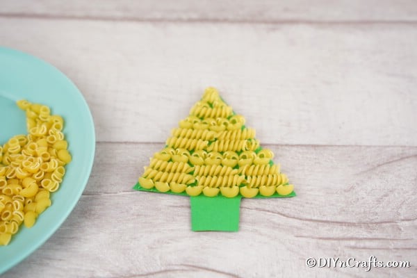 Gluing pasta to a christmas tree craft