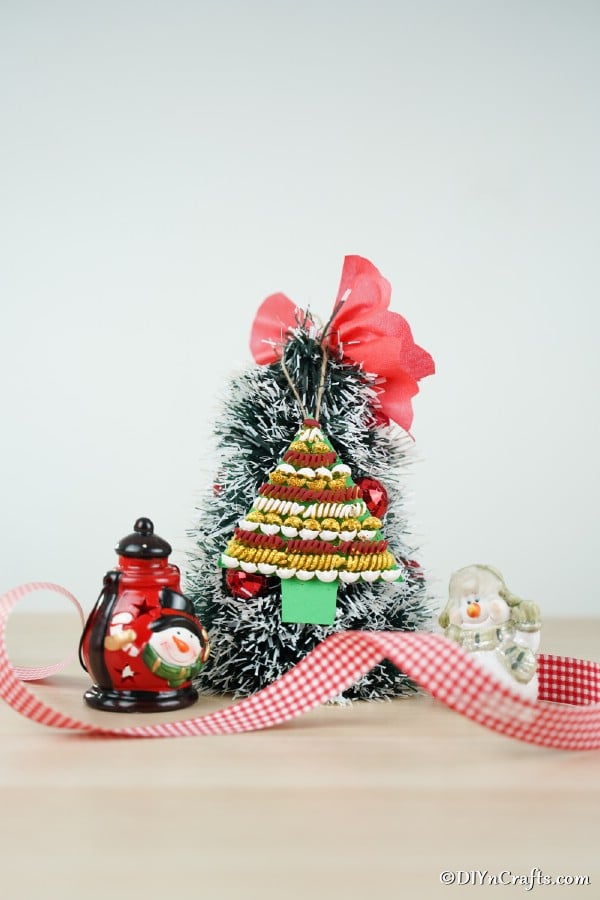 A small tree with a pasta Christmas tree decoration hanging on the front with red ribbon