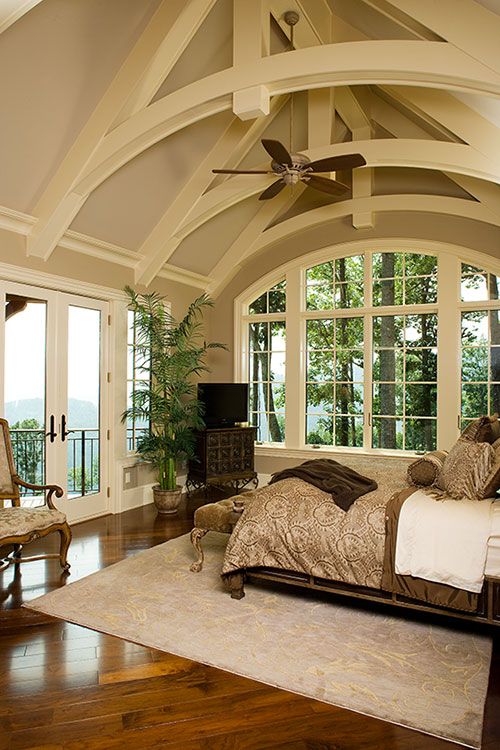 Bedroom with vaulted ceiling and large windows