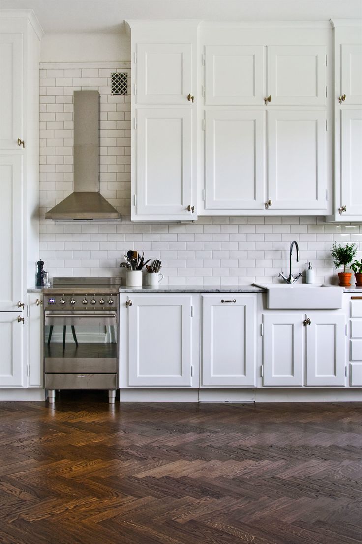 White kitchen design with a rustic floor