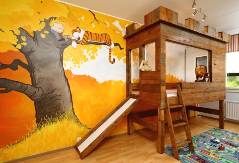Деревянная кровать в детской с рисунком на стене
