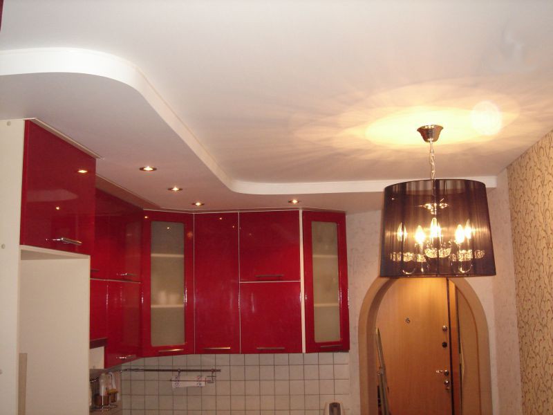 Красные шкафы под потолком современной кухни