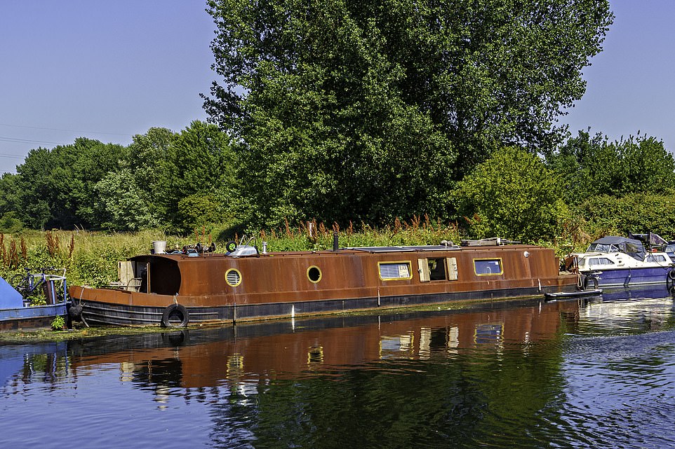 The luxurious houseboat is made of a sustainable type of steel which gives it is distinctive orange, rusty look on the outside