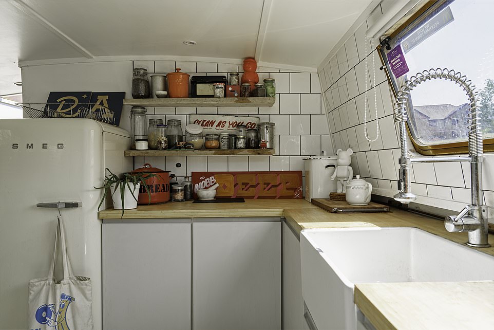 The impressive houseboat has a large rustic kitchen-dining area, with a working sink, wooden worktops and a full size Smeg fridge