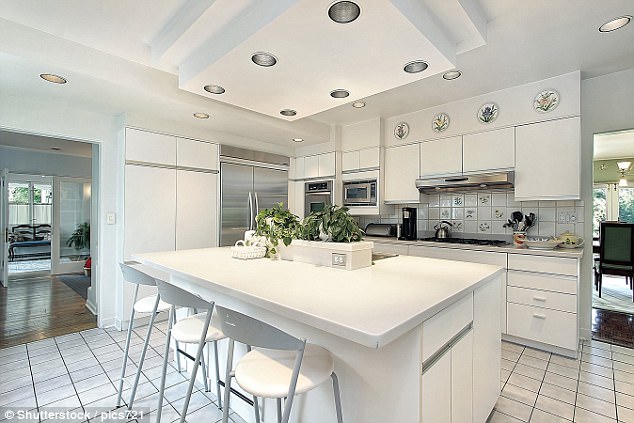 This kitchen is dazzlingly white, with ceiling-to-floor white cabinets and work surfaces and a large kitchen island unit