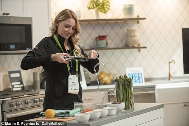 Whirlpool is set to launch the free new  app, Yummly 2.0, in the spring or summer. While it can work with Whirlpool appliances, its starring ‘ingredient recognition’ feature doesn’t require you own a smart refrigerator. Above, a Whirlpool exhibitor demonstrates the new app at CES