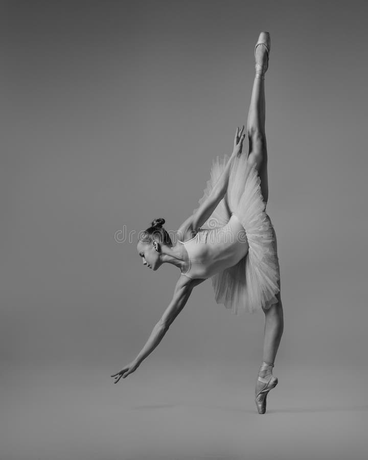 The ballerina reaches for the floor b&w stock images