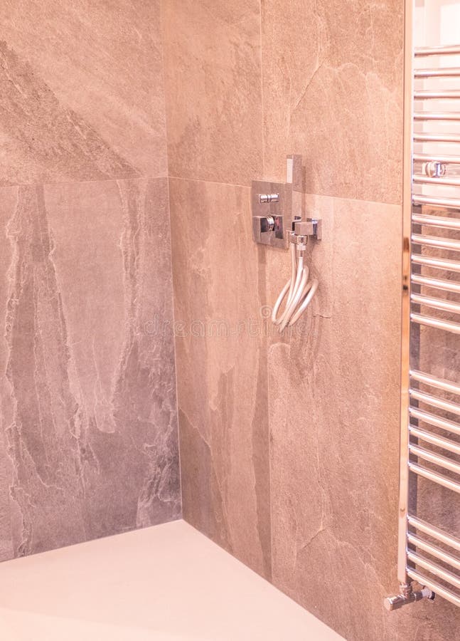 Bathroom with, shower cabin, large mirror and chrome silver heater or towel radiator at grey wall. Loft style in new apartment. royalty free stock image