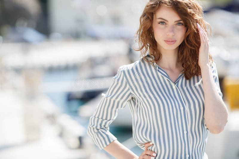 Beautiful girl on the pier next to the yacht club royalty free stock image