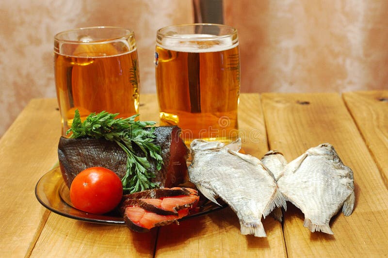 Beer and fish on table stock photos