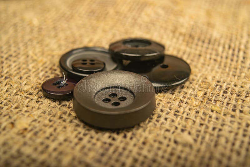 Buttons of different sizes on burlap with a rough texture. Close up.  stock image