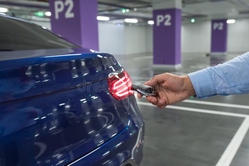 Car Keys. Male hand, holding car key opens blue car royalty free stock photos