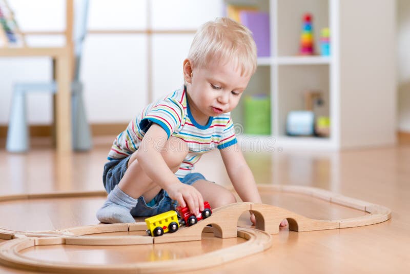 Child boy playing in his room with a toy train. Child playing in his room with a toy train royalty free stock photo