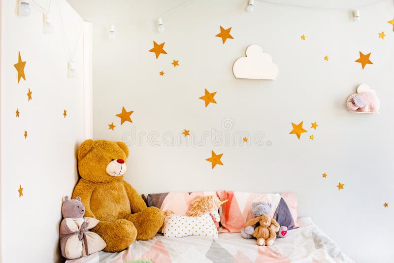 Child dream concept. Cosy bedroom decorated with toys and stars. Stars and white clouds on walls royalty free stock photo