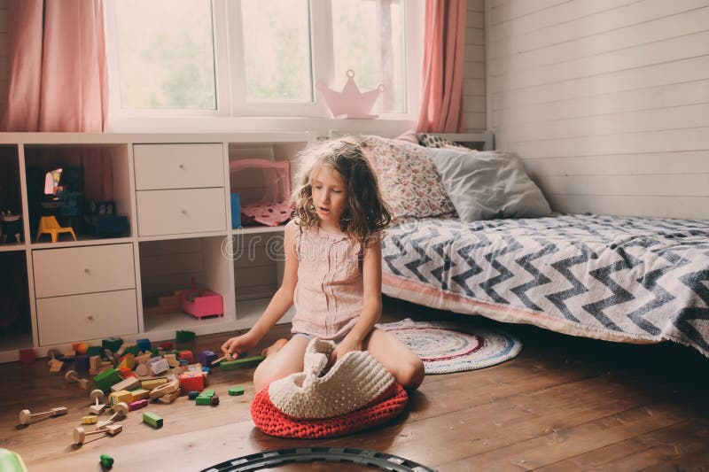 Child girl cleaning her messy room. And put toys in basket royalty free stock photo