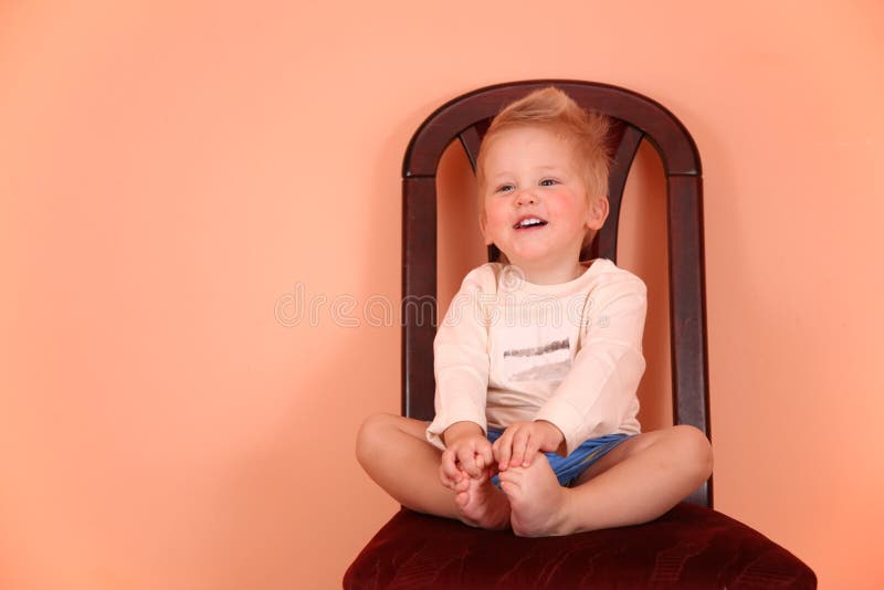 Child sit on chair in pink room. The child sit on chair in pink room royalty free stock photo