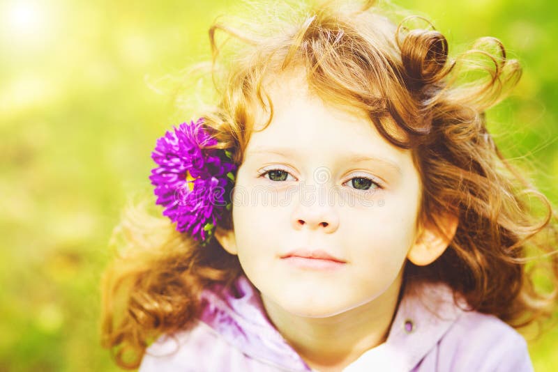 Curly girl with flower in her hair. Toning photo. Instagram filter. stock images