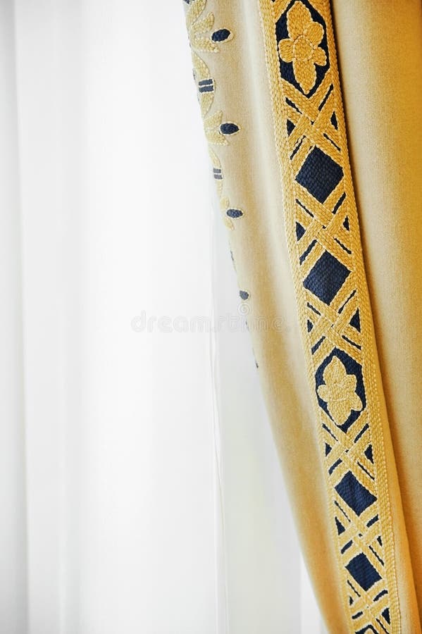 Elegant window curtain. Elegant yellow window curtain shot against outdoor light stock photos