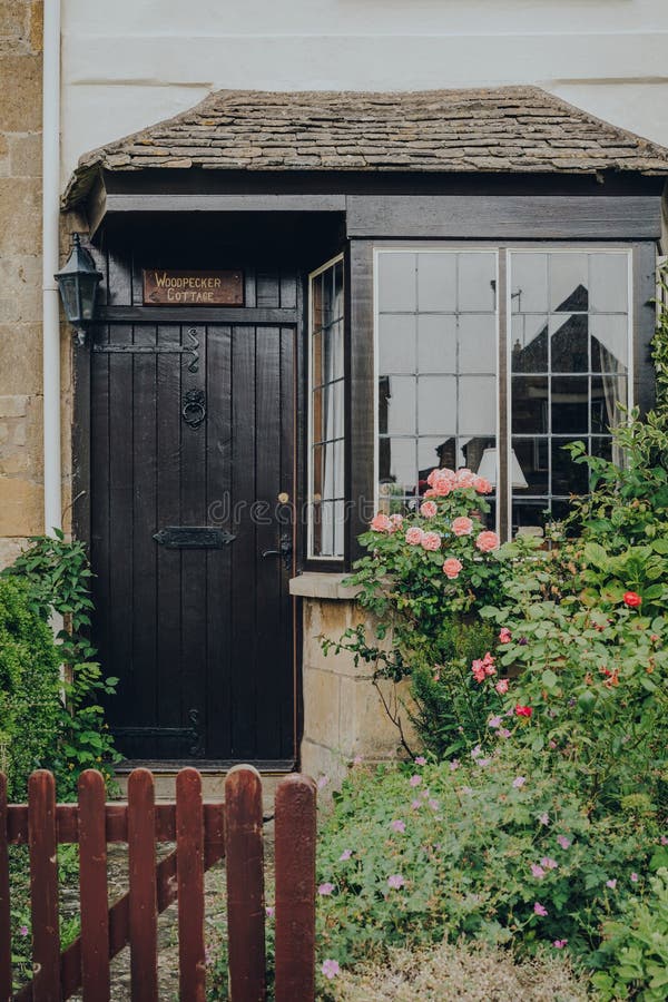 Front door and bay window of a house in Broadway, Cotswolds, UK, view over the gate stock photos