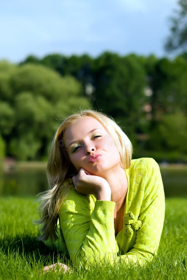The girl lays on a grass stock images