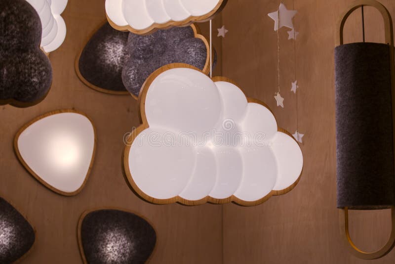 The lamp for the nursery in the form of a cloud, the concept of the interior for the children`s bedroom. Hanging lamp in the royalty free stock photography