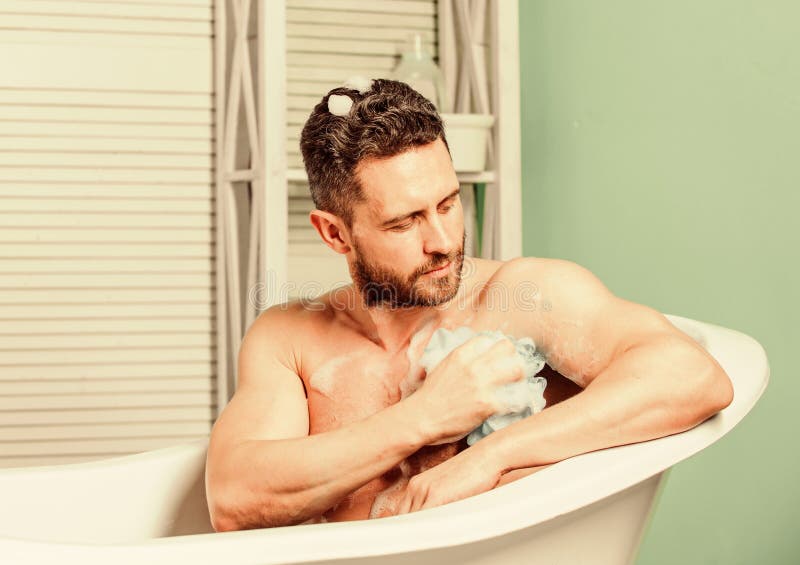 Man wash muscular body with foam sponge. hygiene and health. Morning shower. macho man washing in bath. desire and. Temptation. personal care. Sexy man in stock image