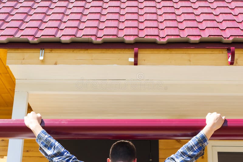 The master tries on the cornice to the roof. The master tries on the cornice the roof stock photography