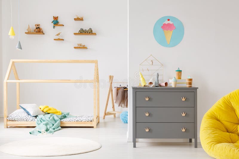 Modern child`s room interior. Grey cabinet against white wall with poster in modern child`s room interior with wooden bed stock images