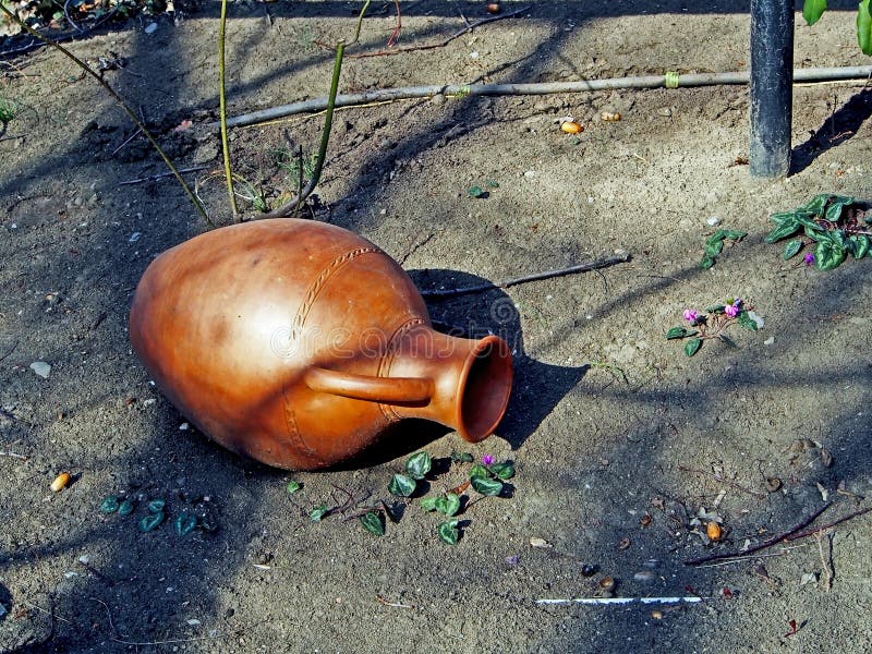 Old jug on the ground in the yard of a roadside restaurant. Old clay jug on the ground in the yard of a roadside restaurant, performs decorative functions royalty free stock photo
