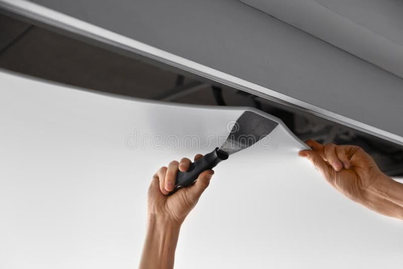 Repairman installing white stretch ceiling in room royalty free stock images