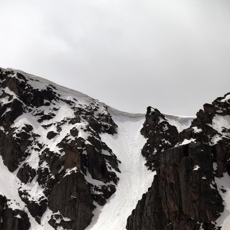 Rock with snow cornice in gray day. Turkey, Kachkar, highest part of Pontic Mountains royalty free stock photo