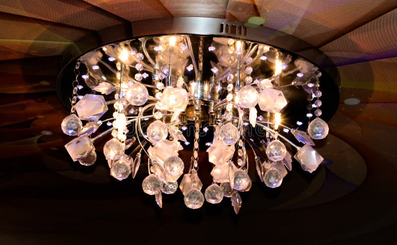 Round chandelier on an abstract stretch ceiling royalty free stock image
