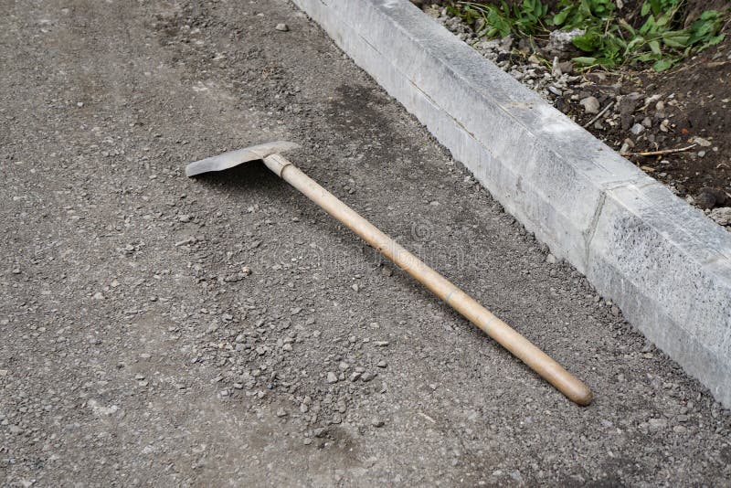 Shovel lying on the ground, repair, yard, new, construction. Pavement curb stock photos
