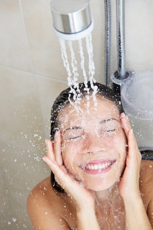 Shower woman washing face. In while showering with happy smile and water splashing. Beautiful mixed race Asian Chinese / Caucasian female model home in shower royalty free stock photography
