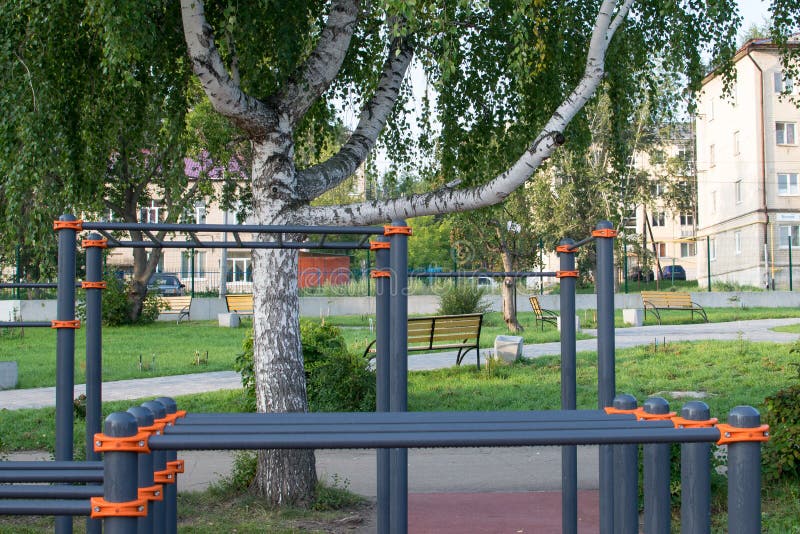 Sports ground with horizontal bar and bars under the birch stock photography