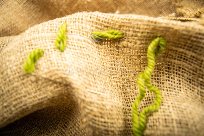 Stitches of green thread on the burlap with a rough texture. Close up.  royalty free stock photos