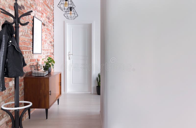 Stylish apartment hall clothes hanger, cupboard and brick wall, real photo. With copy space stock photo