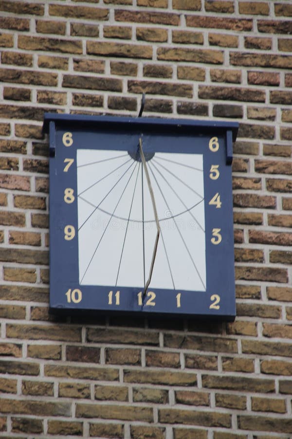 Sundial on the wall of the ancient town hall of the city of Haastrecht in the Netherlands royalty free stock photo
