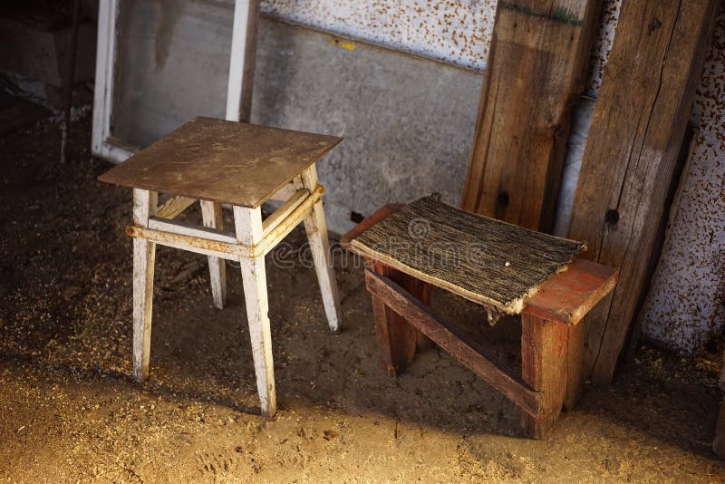 Two old low wooden chair in a rural yard on the ground.  stock photo