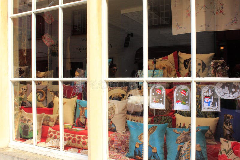 Typically Belgian cushions on shop window. Belgian tapestry cushions, tablemats, tapestry throws, bedspreads and shams, wall hangings, draught excluders and the stock photo