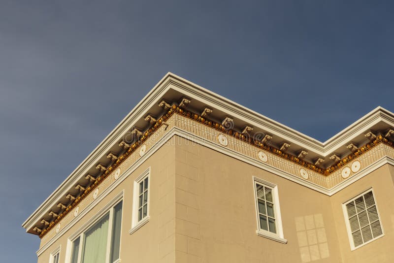 Upscale house roof and cornice detail. Detail of the roof and cornice of an upscale modern home against a blue sky stock photo
