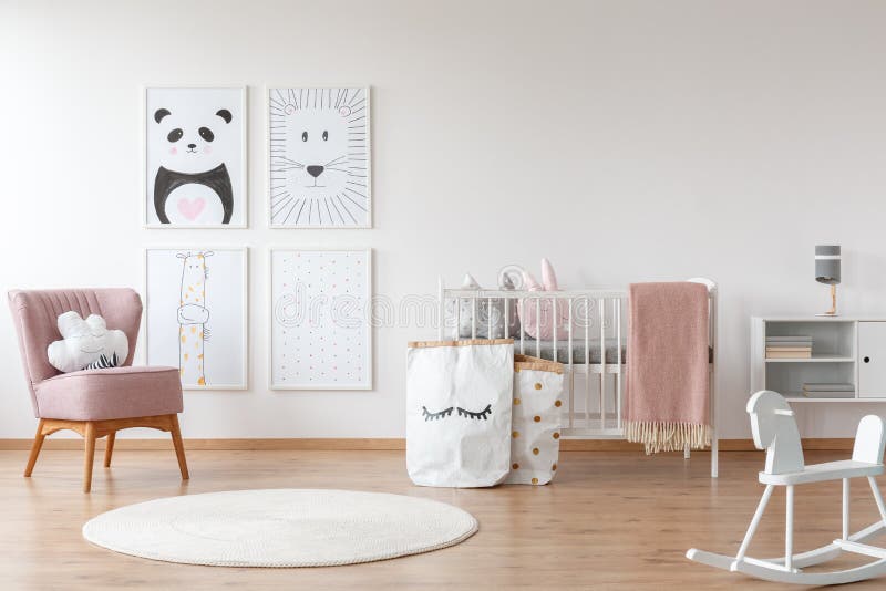 Pink armchair in child`s room. White rocking horse and carpet in child`s room with pink armchair, paper bags, drawings and bed stock photos