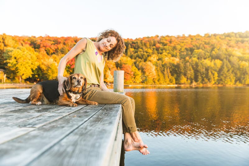 Woman and dog relaxing on the dock royalty free stock images