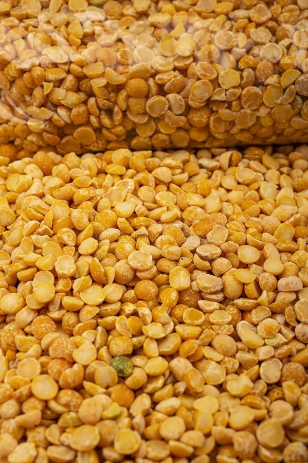 YelloYellow split peas in a plastic bag and cereal in bulk on a background of burlap with a rough texture. Traditional cereals for. Yellow split peas in a stock images