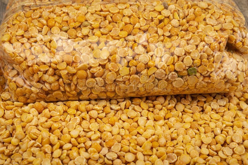 YelloYellow split peas in a plastic bag and cereal in bulk on a background of burlap with a rough texture. Traditional cereals for. Yellow split peas in a royalty free stock image