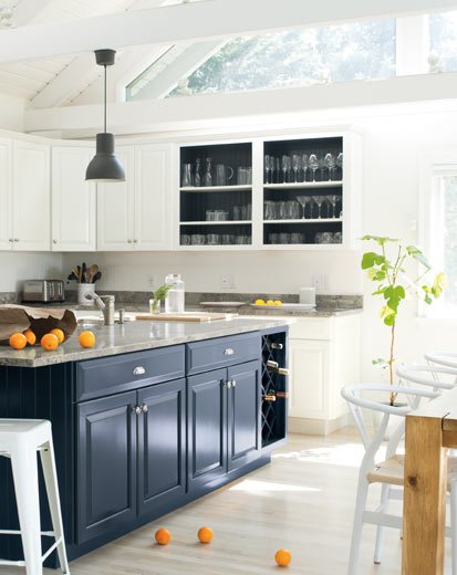 A bright, airy kitchen with blue island and white walls and cabinets